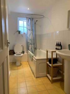 a bathroom with a tub and a toilet and a sink at Large Apartment - 20 mins to the City in London