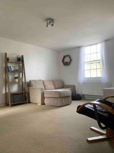 a living room with a couch and a window at Large Apartment - 20 mins to the City in London