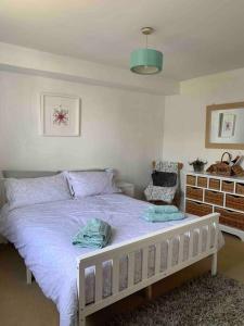 a bedroom with a bed with purple sheets and a chair at Large Apartment - 20 mins to the City in London