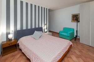 1 dormitorio con 1 cama y 1 silla azul en Le Ruote, en Vezzano sul Crostolo