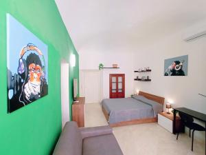 sypialnia z łóżkiem i zieloną ścianą w obiekcie Le Stanze del Corso w mieście Ascoli Piceno