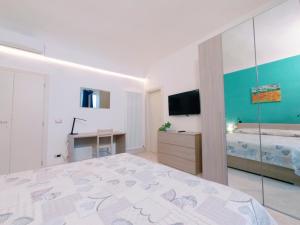 una camera con un grande letto e una televisione di Le Stanze del Corso ad Ascoli Piceno