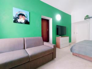 salon z kanapą, łóżkiem i telewizorem w obiekcie Le Stanze del Corso w mieście Ascoli Piceno