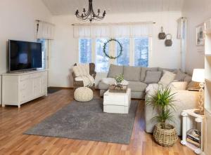 a living room with a couch and a tv at Arctic Circle Home close to Santa`s Village in Rovaniemi