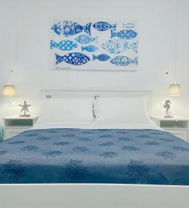 1 cama con placas azules y blancas en la pared en Seashell Guest House, en Torre Marino