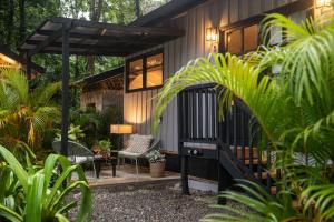 a house with a porch with a chair and a table at KAÑIK APART HOTEL in Puerto Viejo