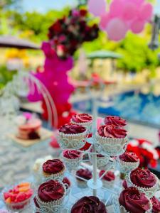 a table topped with cupcakes with red frosting at The Kingslayer Resort in Negombo
