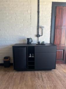 a black cabinet in a room next to a wall at ROCCHETTA HOTEL BOUTIQUE in Sierra de los Padres