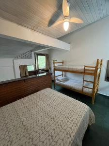 a bedroom with two bunk beds and a ceiling fan at Chales da Lua Juquehy in Juquei