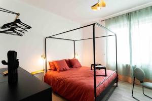 1 dormitorio con cama roja y dosel de cristal en Appartement T3 la perle verte en Agde