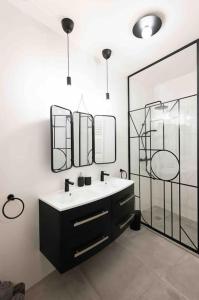 a bathroom with a sink and two mirrors at Appartement T3 la perle verte in Agde