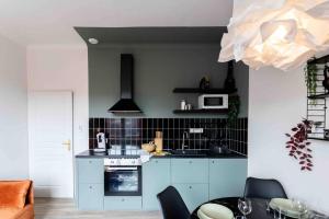 a kitchen with blue cabinets and a stove top oven at Appartement T3 la perle verte in Agde