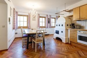 a kitchen and dining room with a table and a stove at Alpina Holiday Living Apartments in Obertauern