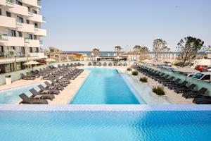 a swimming pool with chaise lounges and chairs at TGM Sunrise View - Infinity Pool & Spa Resort in Mamaia Nord