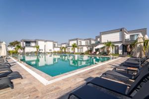 a swimming pool with chaise lounges and chairs at Seaside Serenity in Bodrum: Luxury Retreat w View in Turgutreis