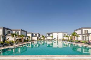 圖爾古特雷伊斯的住宿－Seaside Serenity in Bodrum: Luxury Retreat w View，部分公寓前方设有大型游泳池。