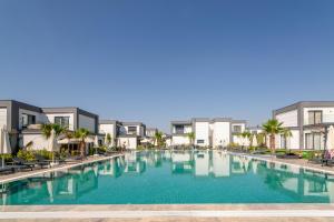 uma grande piscina em frente a alguns apartamentos em Seaside Serenity in Bodrum: Luxury Retreat w View em Turgutreis