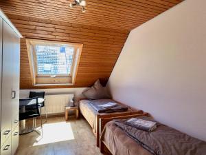 1 dormitorio con cama, escritorio y ventana en Ferienhaus Can Miguel - Urlaubsoase in ruhigem Wohngebiet, en Lindau-Bodolz