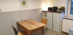 Apartment Mörlenzauber في Ober-Mörlen: غرفة مع طاولة خشبية في غرفة