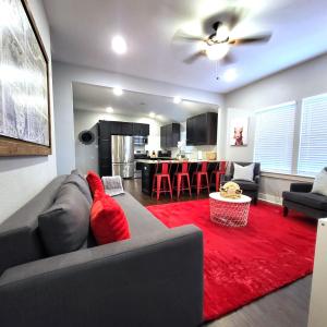 a living room with a couch and a red rug at Vibrant Vacation Escape with Fast WIFI and KING BED Close to Downtown Houston! in Houston