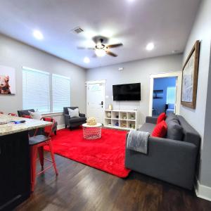 a living room with a couch and a red rug at Vibrant Vacation Escape with Fast WIFI and KING BED Close to Downtown Houston! in Houston