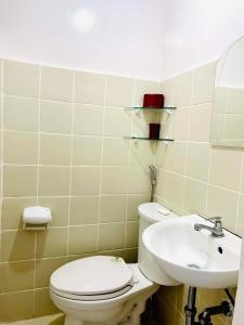 y baño con aseo y lavamanos. en 9th floor Taal View with 2 Balconies w/ Fiber Net, en Tagaytay