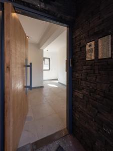 eine offene Tür zu einem Zimmer mit Ziegelwand in der Unterkunft Loretta IV in San Martín de los Andes