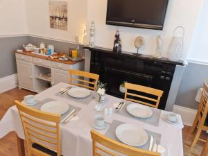 uma sala de jantar com uma mesa branca e cadeiras em The Chimes em Bridlington