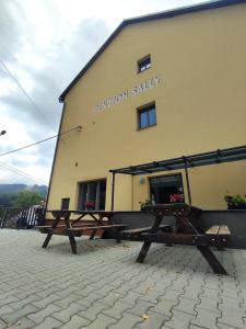 a building with two picnic tables in front of it at Penzion Sally in Albrechtice v Jizerských horách