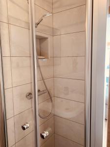 a shower with a glass door in a bathroom at Dachgeschoss-Ferienwohnung in Sonthofen