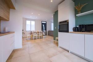 eine Küche mit weißen Schränken und ein Esszimmer in der Unterkunft Ty Glas charmante maison 200 m de la plage in Ploudalmézeau + 13 Fotos