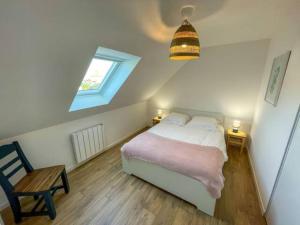 ein Schlafzimmer mit einem Bett, einem Fenster und einem Stuhl in der Unterkunft Ty Glas charmante maison 200 m de la plage in Ploudalmézeau