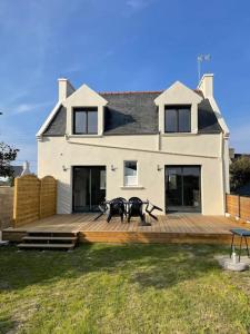 ein Haus mit einer großen Holzterrasse davor in der Unterkunft Ty Glas charmante maison 200 m de la plage in Ploudalmézeau