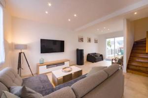ein Wohnzimmer mit Sofa und Fernseher in der Unterkunft Ty Glas charmante maison 200 m de la plage in Ploudalmézeau