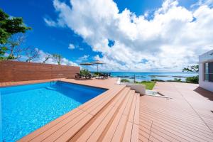 a swimming pool on a deck with a view of the ocean at クリスタルヴィラ南城 in Azama