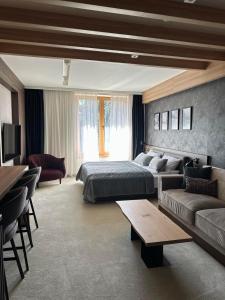 a bedroom with a bed and a couch and a table at WOODSIDE Apartment M Kopaonik FREE Parking in Kopaonik