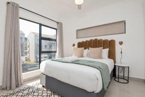 a bedroom with a large bed with a large window at Ballito Village Luxury Apartments in Ballito