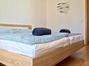 ein Schlafzimmer mit einem Bett mit blauen Kissen darauf in der Unterkunft Ferienwohnung Bodenseele - Wohlfühloase mit großem Sonnenbalkon in Langenargen