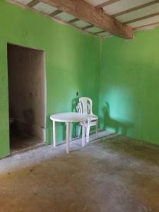 a white table and two chairs in an empty room at EcoCamp TV Cristã Web in Cabo de Santo Agostinho