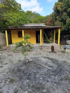 a yellow house with yellow pillars in front of it at EcoCamp TV Cristã Web in Cabo de Santo Agostinho