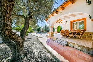 an outdoor patio with a table and a tree at Villa Angeles Tur in Calpe