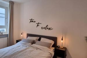 a bedroom with a bed and a sign that reads take me believe at Stylisches Apartment in zentraler Lage mit Balkon in Karlsruhe