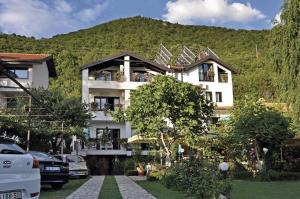 a white building with a hill in the background at Villa Klia in Ohrid