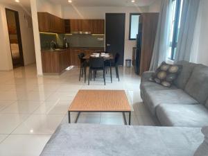 uma sala de estar com um sofá e uma mesa em Ipoh Tambun Sunway Onsen Suite 3R2B Maya em Tambun