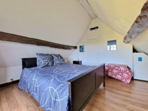 1 dormitorio con 1 cama con edredón azul en Longère Normande - Center Parcs - Proximité GR, en Bourth