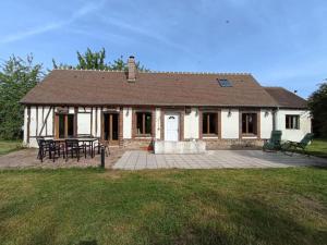 una casa blanca con una mesa de picnic delante de ella en Longère Normande - Center Parcs - Proximité GR, en Bourth