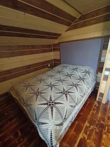 a large bed in a room with a wooden floor at Girskyi Kutochok in Verkhovyna