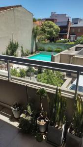a balcony with potted plants and a swimming pool at Zona Güemes. Piscina climatizada. Hermoso 2 amb. in Mar del Plata