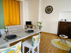 sala de estar con mesa, sillas y reloj en LE SAINT CYRICE, en Rodez