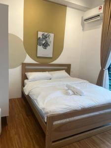 1 dormitorio con 1 cama con sábanas blancas en Harmony and Deluxe Studio Subang Jaya, en Subang Jaya